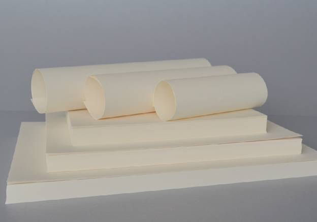 White stationery paper rolls and sheets arranged on a flat surface, used for printing, crafting, and office purposes.